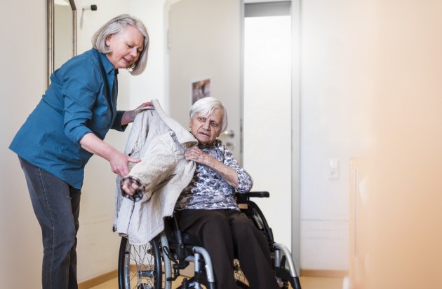 Oprechte aandacht - mantelzorger met vrouw in rolstoel 