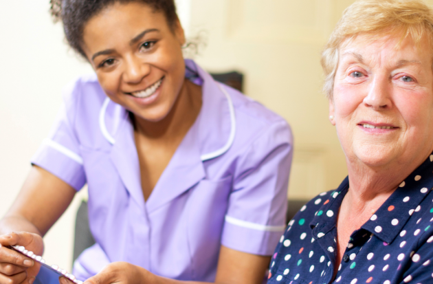 Verpleegkundige geeft pillen aan oudere