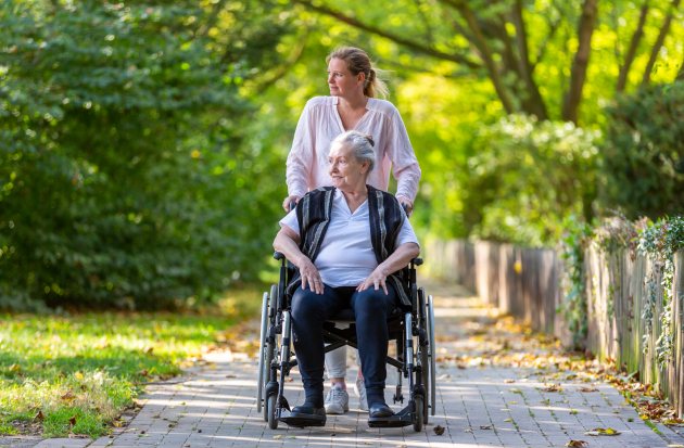 dame in rolstoel met mantelzorger