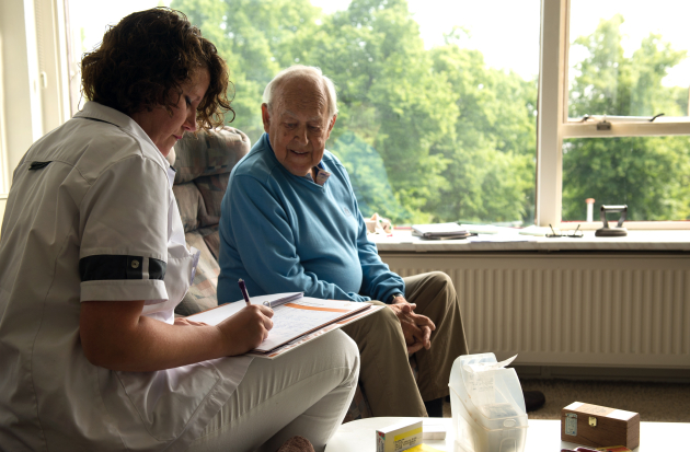 verpleegkundige in gesprek bij client thuis