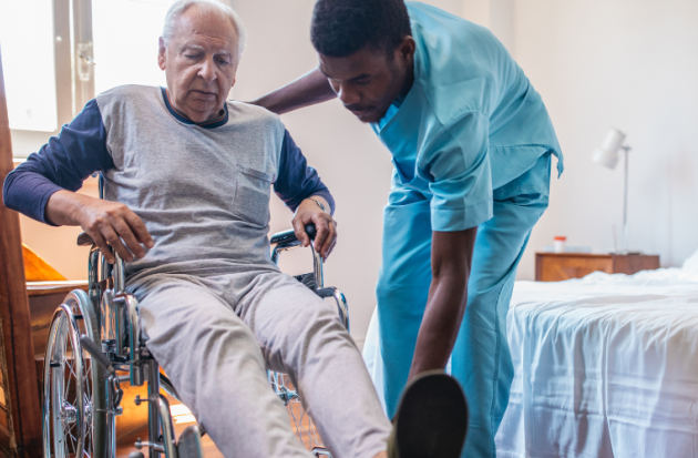 Zorgverlener helpt man uit rolstoel