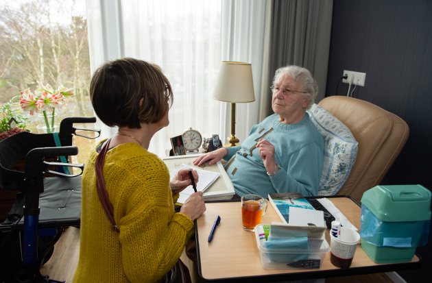 Thuis zorg in gesprek met vrouw