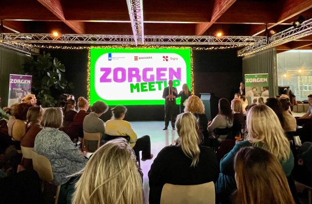 Minister Bruijs (VWS) in gesprek met gespreksleider Sabine Uitslag in een zaal met mensen