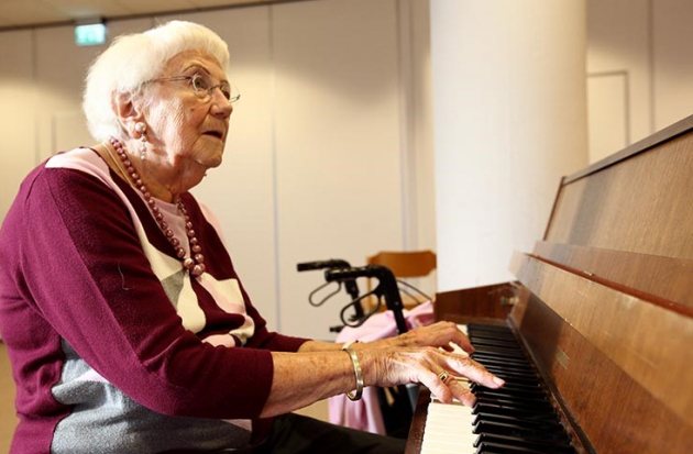 Oudere dame achter piano 