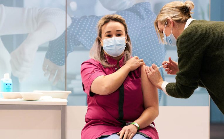 Verzorgende Sanna Elkadiri ontvangt de eerste vaccinatie - foto Phil Nijhuis