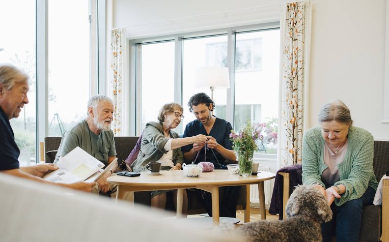 Huiskamer met diverse bewoners en verzorgenden