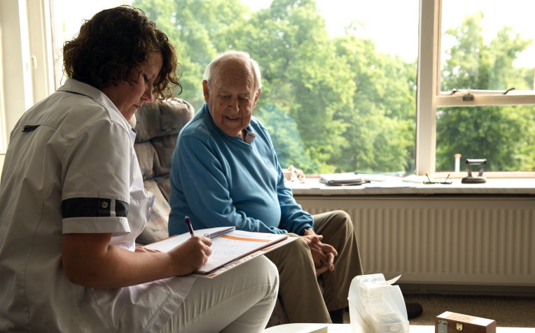 verpleegkundige in gesprek bij client thuis