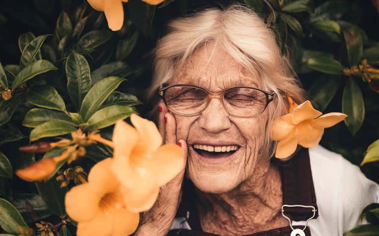 Oudere dame tussen de bloemen