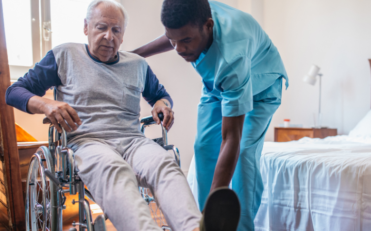 Zorgverlener helpt man uit rolstoel