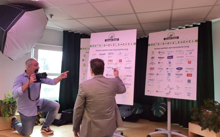 Persoon zet handtekening op een bord