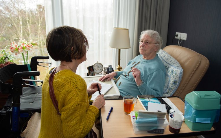 Thuis zorg in gesprek met vrouw