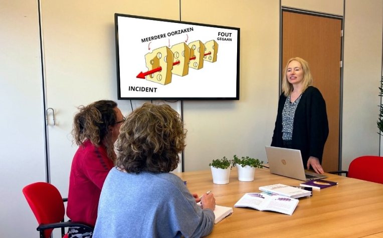 Drie mensen in een vergaderkamer