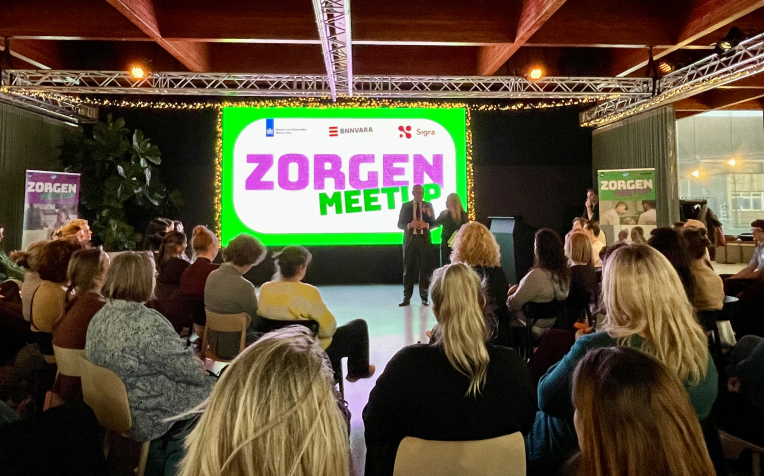 Minister Bruijs (VWS) in gesprek met gespreksleider Sabine Uitslag in een zaal met mensen