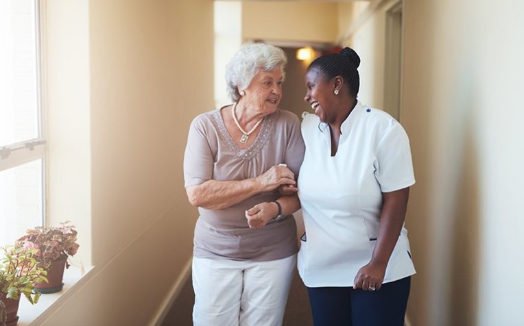 Zorgverlener met dame in gang