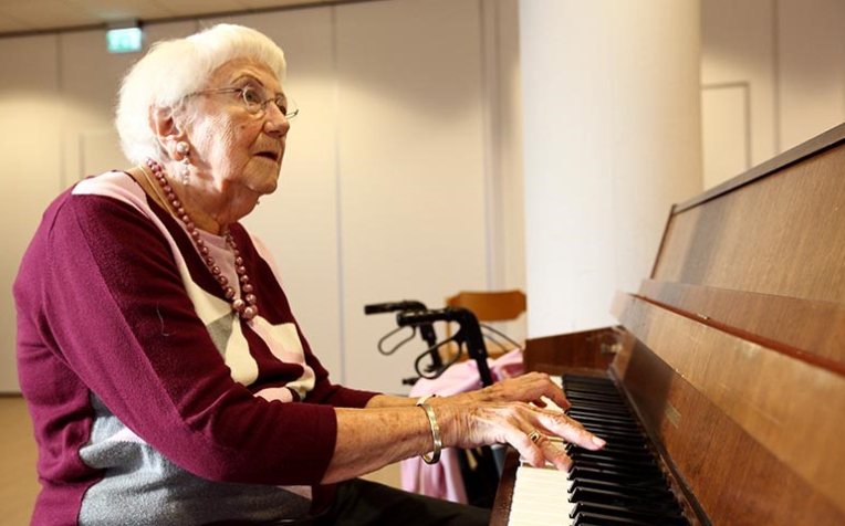 Oudere dame achter piano 