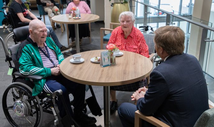 Koning Willem-Alexander praat met enkele bewoners onder het genot van een kopje koffie. © Fotostudio Wierd 