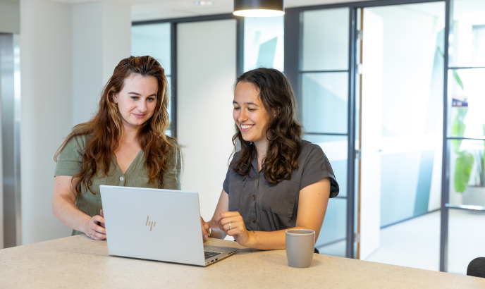 Twee collega's van ActitZ staan bij een laptop