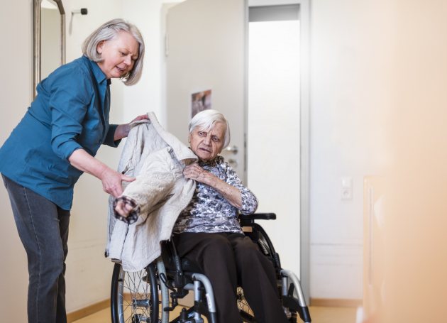 Oprechte aandacht - mantelzorger met vrouw in rolstoel 