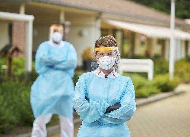 Zorgmedewerkers in beschermende kleding