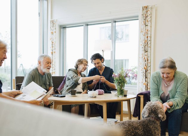 Huiskamer met diverse bewoners en verzorgenden