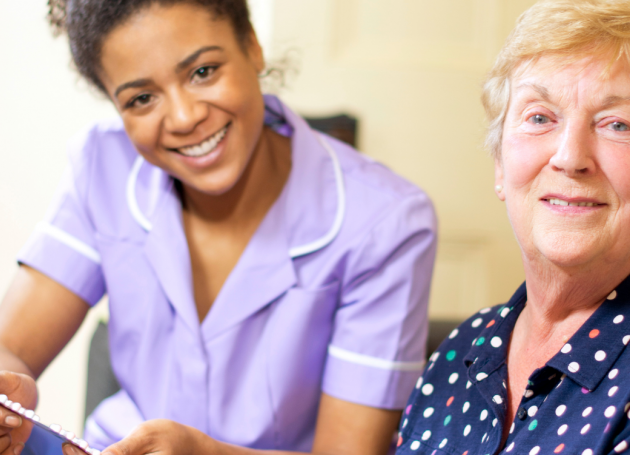 Verpleegkundige geeft pillen aan oudere