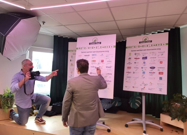 Persoon zet handtekening op een bord