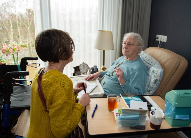 Thuis zorg in gesprek met vrouw