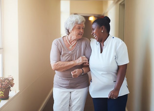 Zorgverlener met dame in gang