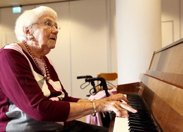 Oudere dame achter piano 