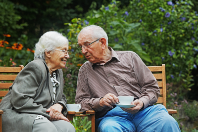 Met liefde en plezier - stel op bankje met kop koffie