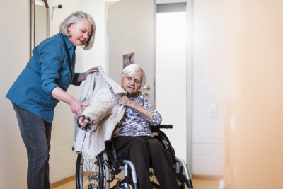 Oprechte aandacht - mantelzorger met vrouw in rolstoel 