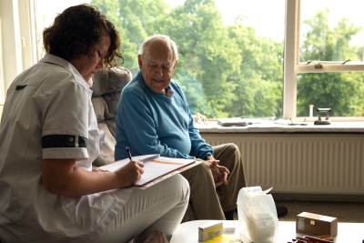 verpleegkundige in gesprek bij client thuis