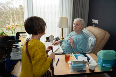 Thuis zorg in gesprek met vrouw